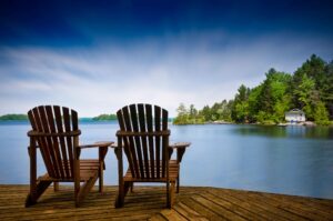Two wooden chairs on private lake dock facing east tennessee lake on sunny day